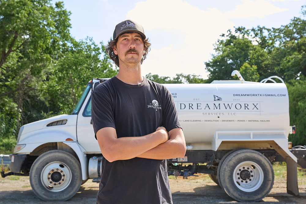 A man, Nick Castillion standing in front of a truck.